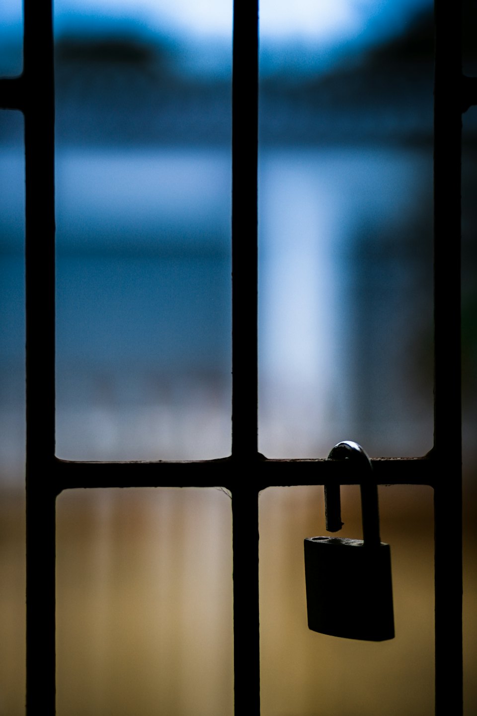 Blocked A dark padlock hangs from a metal grill.
